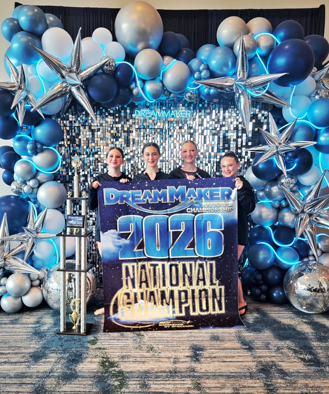 IMPACT dancers holding the 2026 DreamMaker National Champion banner with their trophy